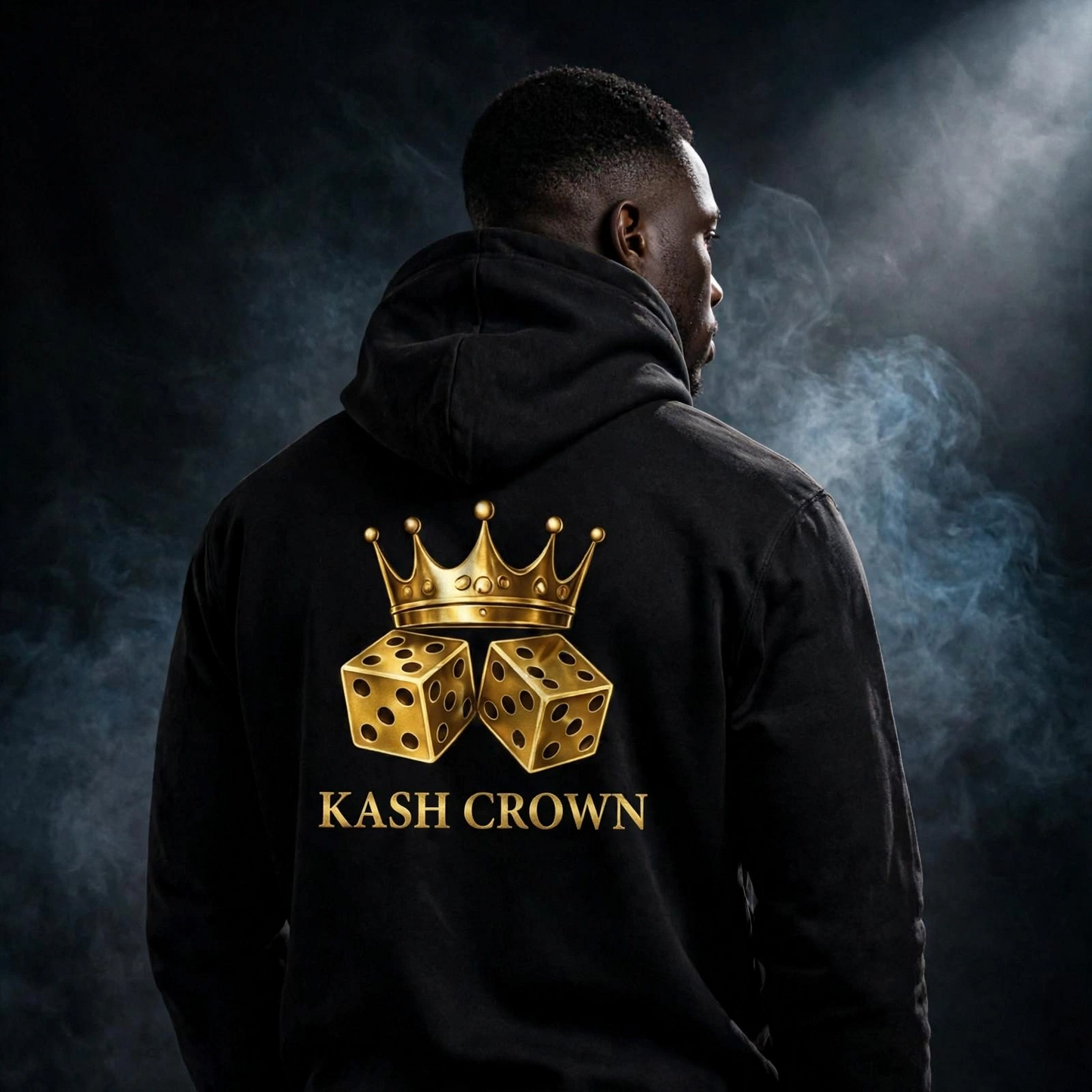 Back view of the black KASH CROWN Crown & Dice Hoodie worn by a model in a dark studio, gold crown and dice graphic above the KASH CROWN wordmark